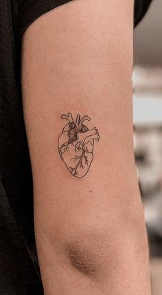 a small heart tattoo on the right side of the left arm is shown in black ink