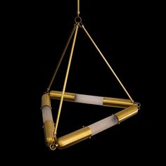 a gold and white chandelier hanging from a chain on a black background,