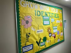 a bulletin board with flowers on it in an office cubicle area that says grow with your identities