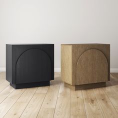 two black and brown wooden boxes sitting on top of a hard wood floor next to each other