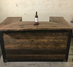 a bottle of wine sitting on top of a wooden table next to a brick wall