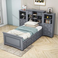 a bed sitting next to a book shelf in a bedroom on top of a hard wood floor