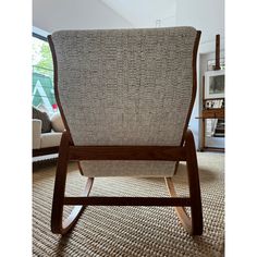 a wooden rocking chair sitting on top of a carpeted floor