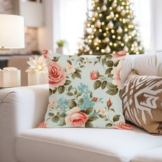 a living room with a christmas tree in the background and pillows on the couches