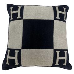 a black and white pillow with the letter h on it