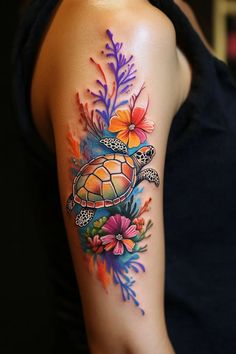 a woman's arm with colorful flowers and a turtle tattoo on her left shoulder