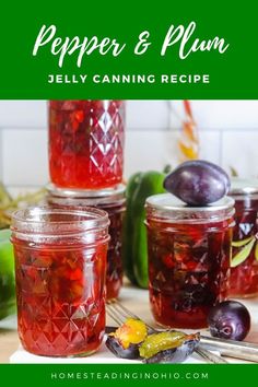 several jars filled with jelly sitting on top of a wooden table next to green peppers and plums