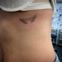 a woman's stomach with a small tattoo on the side of her body,