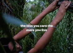 two hands reaching up to each other in front of some tall grass with the words, the less you care the more you live