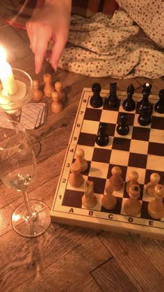 a person playing chess on a wooden table