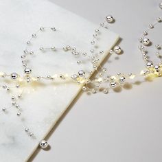 a white marble table topped with pearls and beads