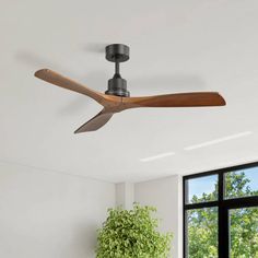 a ceiling fan in a living room next to a window with a potted plant