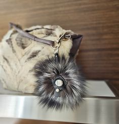 a fur bag with a metal handle on a shelf