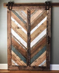 an old door made out of wooden planks and painted with white, blue, green and