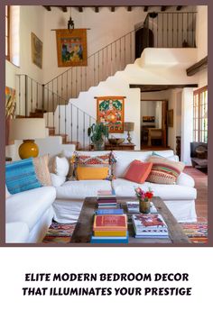 a living room with white couches and colorful pillows on the floor next to a stair case