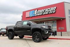 a black truck parked in front of an american power and life store