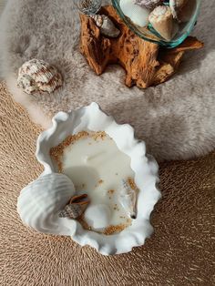 shells and seashells are sitting on the floor next to a glass bowl filled with milk