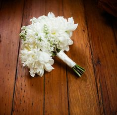 a bouquet of white flowers sitting on top of a wooden floor