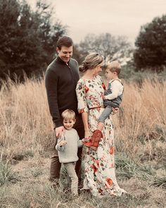 a man, woman and two children standing in a field