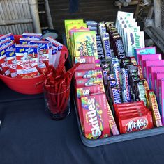 a table topped with lots of candy bars and buckets filled with candy bar wrappers