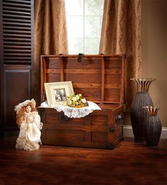 an antique trunk with flowers in it sits on the floor next to a decorative vase