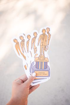 a person holding up some stickers in their hand with an image of people on them