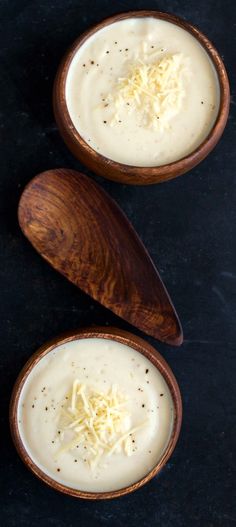 two wooden bowls filled with soup and cheese