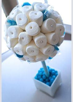 a bunch of marshmallows in a vase on top of a white table