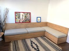 a corner couch in the middle of a living room with a rug on the floor