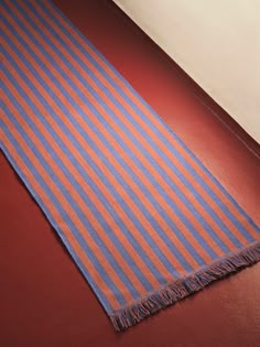 an orange and blue striped towel laying on the floor