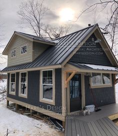 a small house with a metal roof in the snow