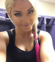 a woman with blonde hair wearing a black tank top and holding a pink pony tail