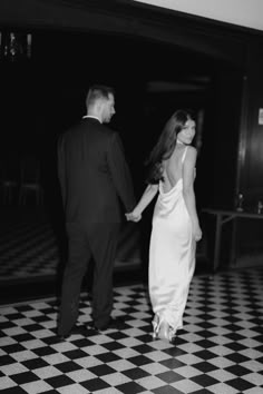 Couple standing on black and white tile floor. Women in white dress looking back at camera, man in black tux looking forward Chic Engagement Shoot, Dressed Up Engagement Photos, Sophisticated Engagement Photos, Black White Engagement Photo, Black Tie Engagement Photos, Cool Girl Engagement Shoot, Old School Engagement Photos, Hollywood Glam Engagement Photos, Engagement Photos Black And White