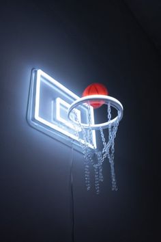 an illuminated basketball hoop with a red ball on it