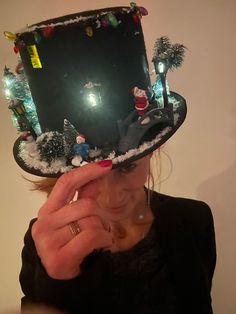 a woman wearing a black hat with christmas decorations on it