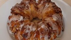 a bundt cake sitting on top of a white plate covered in icing and drizzle