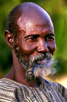 an old man with a pipe in his mouth