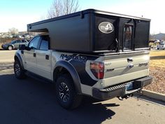 a truck with a camper attached to it's back in a parking lot