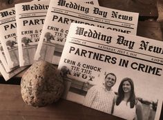 four newspapers and a rock on a wooden table