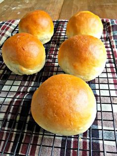 four bread rolls sitting on top of a cooling rack