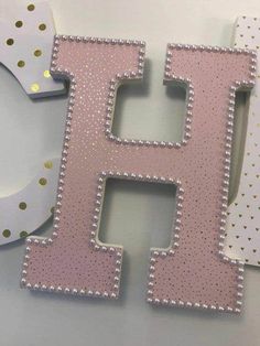 the letter h is made out of pink and white polka dot paper with gold dots