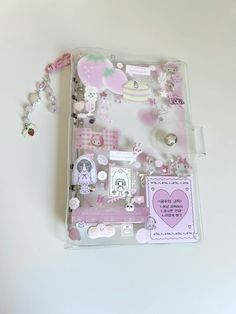 an open binder with lots of different items on it, including beads and charms