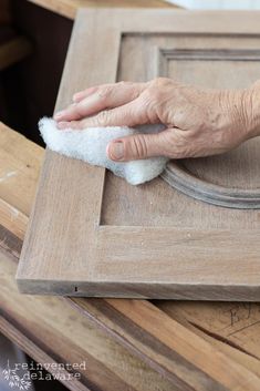 an older person is cleaning the wood with a cloth