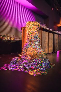 a colorful object is sitting on the floor in front of a purple wall and bar