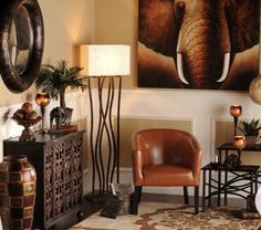 a living room with an elephant painting on the wall and two chairs in front of it