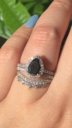 a woman's hand with two rings on it and a black diamond in the middle