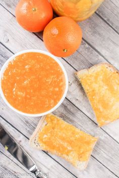 two oranges and some bread on a wooden table