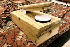 a wooden box with a hockey puck in it sitting on the floor next to a rug