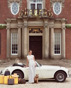 a woman standing next to a white car in front of a building