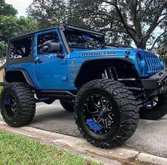 a blue jeep is parked on the street